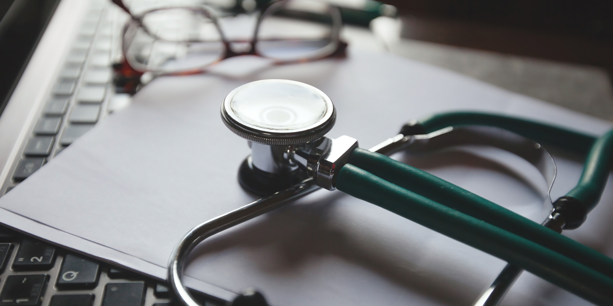 A stethoscope laying on a laptop keyboard, a representation of how healthcare and technology can supplement and improve each other.