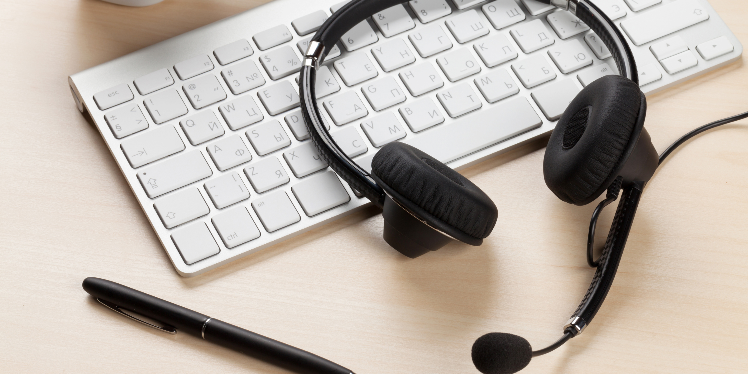 Receptionist headset on keyboard for blogpost about phone tree software.