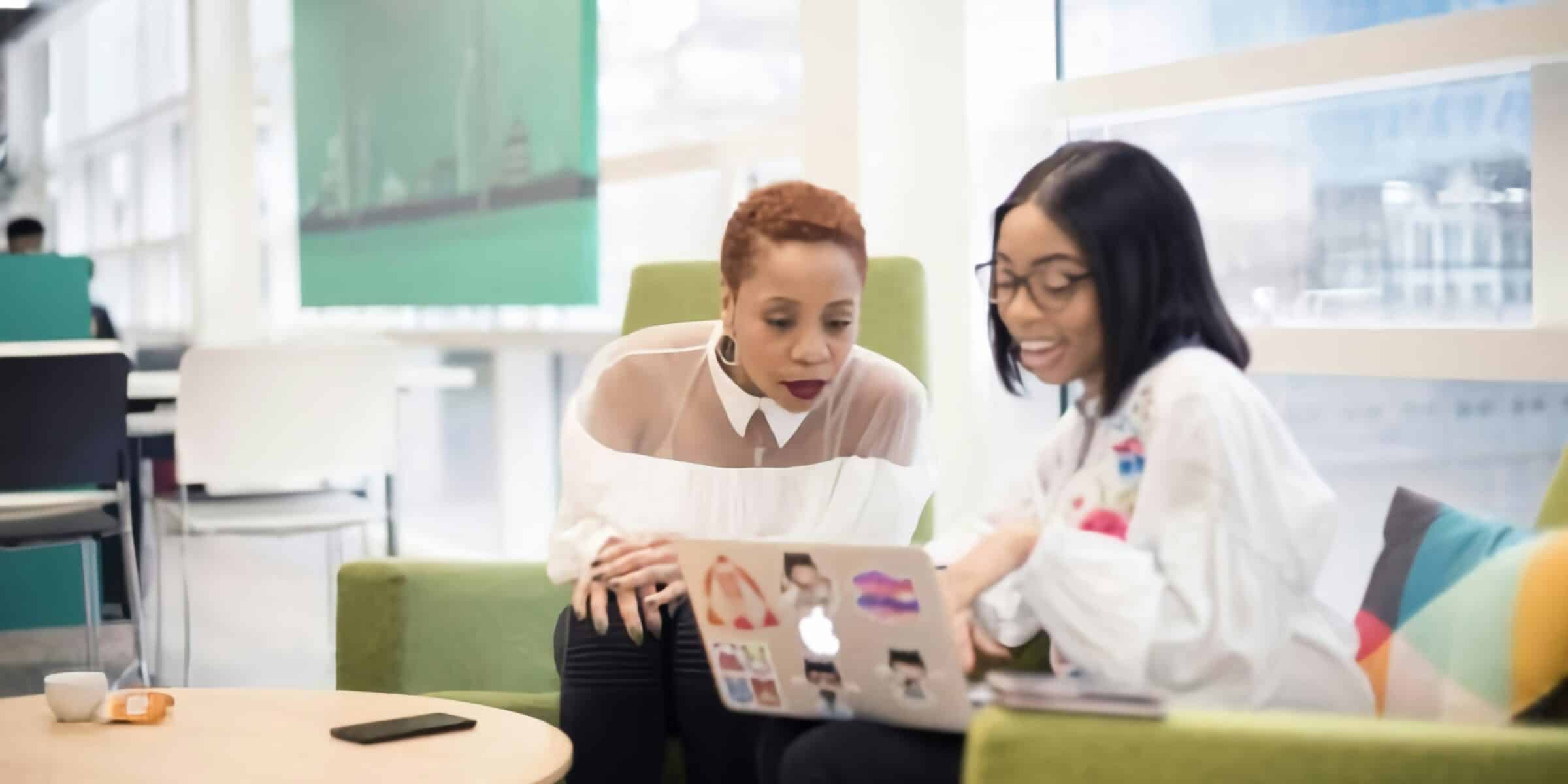 doctor explaining something to a patient while on a computer and seated on a couch
